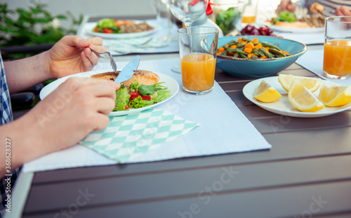 Close up photo of hands man eating salad  quinoa and fish on terrace