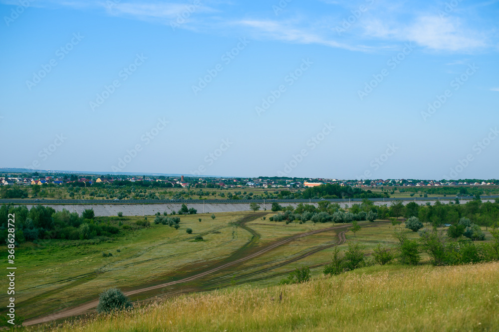 landscape with a view of a winding country road. the village is far away. track.