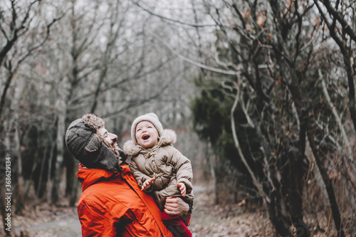 Handsome bearded young dad and his little sweet daughter have fun outdoors in winter.  Family concept.