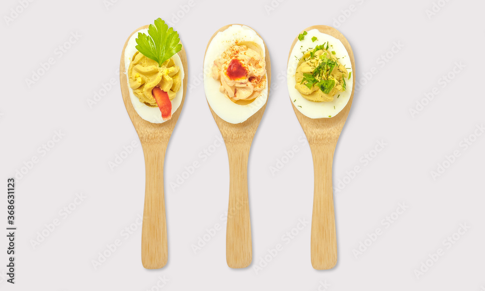 Stuffed egg on spoon on a white background Stuffed egg on spoon on a white background