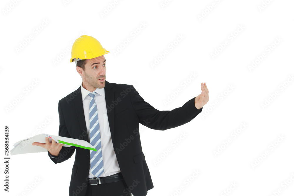 Handsome and smart engineer in black suit Wearing a yellow safety engineer hat with hand holding Construction drawing papers and serious in work isolated on yellow background. Copy Space Handsome and smart engineer in black suit Wearing a yellow safety engineer hat with hand holding Construction drawing papers and serious in work isolated on yellow background. Copy Space