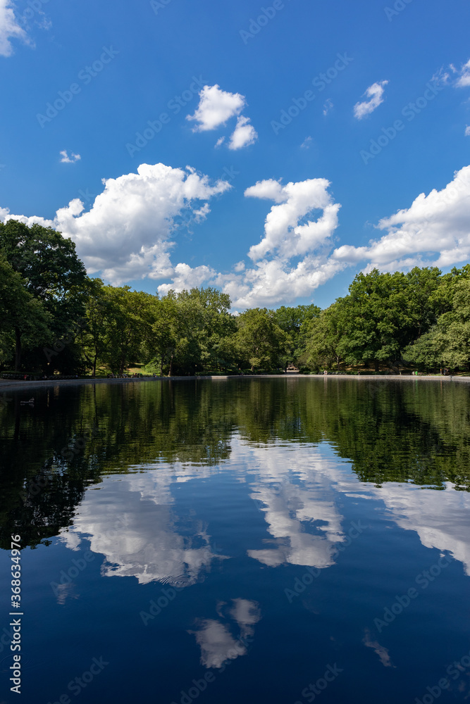 Beautiful Reflections of Clouds and Trees on the Conservatory Water Pond at Central Park during Summer in New York City