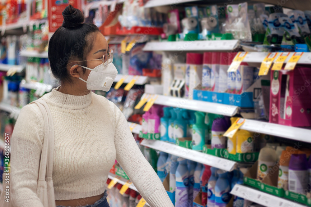 Young Asian women wearing face mask with canvas bag buying in supermarket.Panic shopping during Covid-19, Sydney Australia.