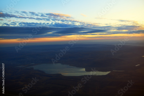 Panoramic view of lake between hills in the dusk . Aerial view of evening nature 