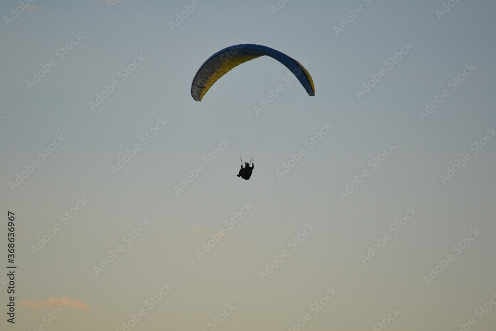 paragliding with summer sun starting to set paragliding with summer sun starting to set