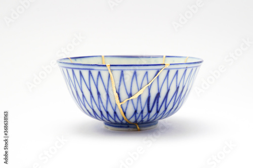 Antique Japanese ceramic kintsugi bowl restored with gold. Antique kintsukuroi technique.