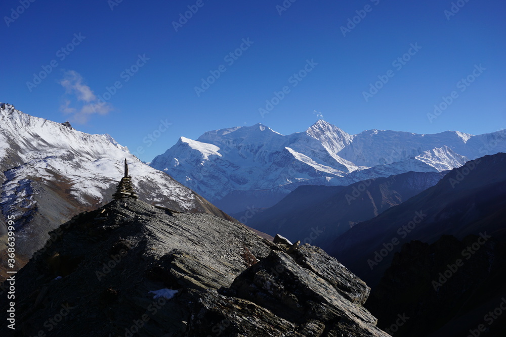 Stacks of rocks arranged as cairn to resemble Chhorten atop a mountain above High Camp in Annapurna Circuit Trail in Nepal.