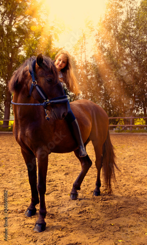 Beautiful and natural young girl spending sometime with her horse. Love and friendship concept.