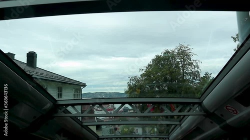 Floyen funicular cabin attraction. View from Bergen and Northern sea panoramic aerial view through cabin's glass roof on cloudy grey cold day. Bergen, Norway photo