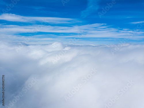 High flight in white curly clouds. © Sergey