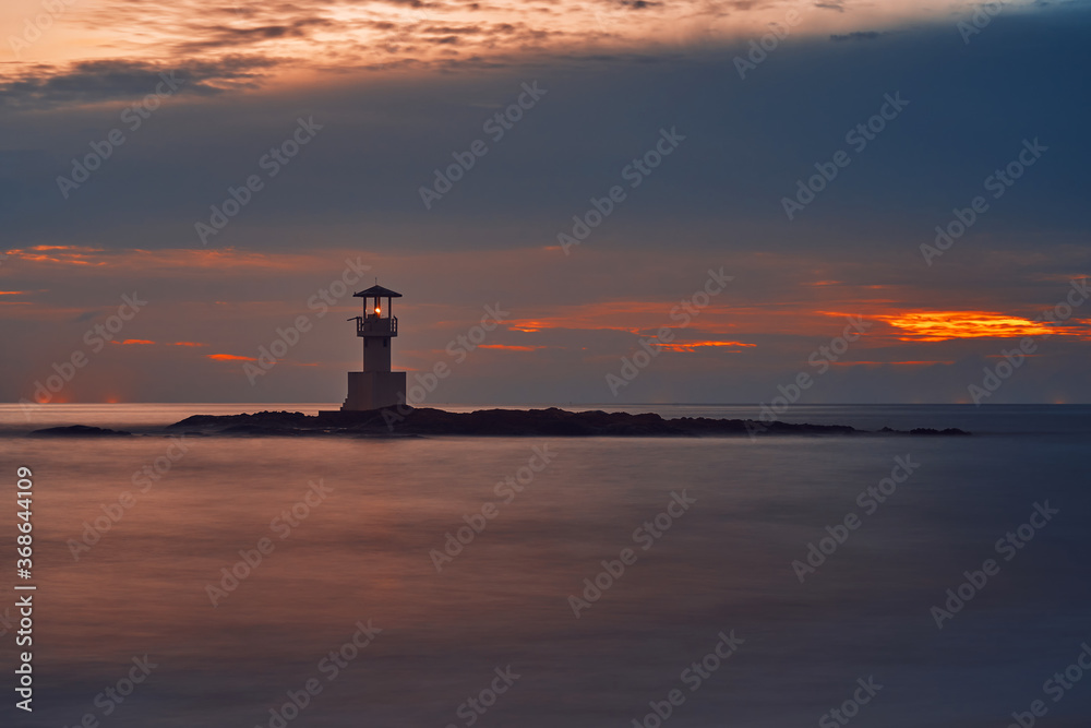 Seascape at sunset. Lighthouse on the coast. long shutter shot