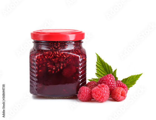 Rasberry jam in glass jar and fresh raspberries isolated on white background