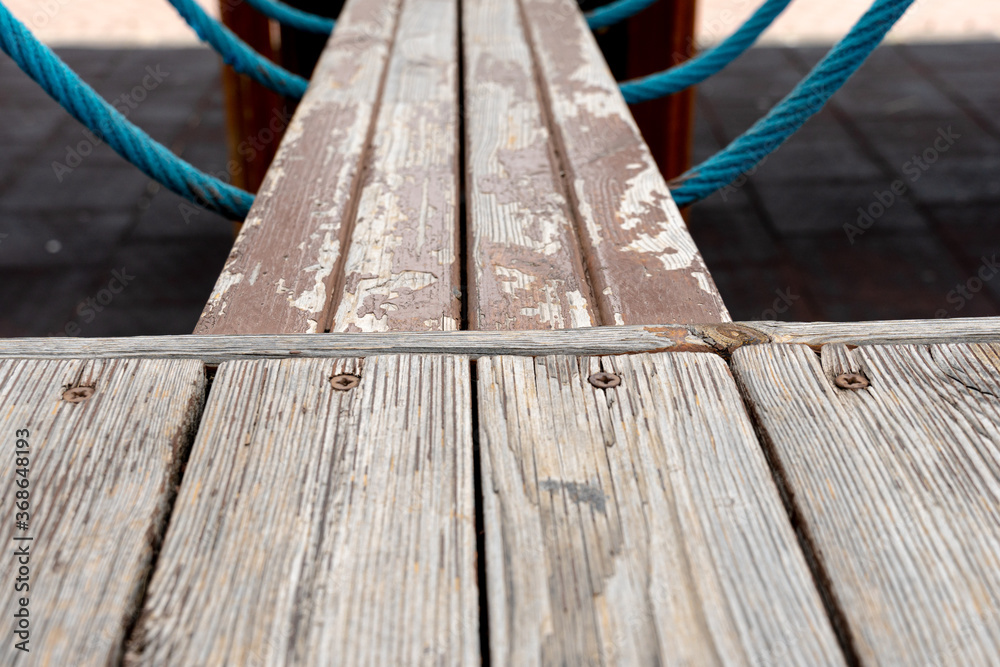 rowing boy catwalk in wooden playground with blue ropes worn by time rowing boy catwalk in wooden playground with blue ropes worn by time