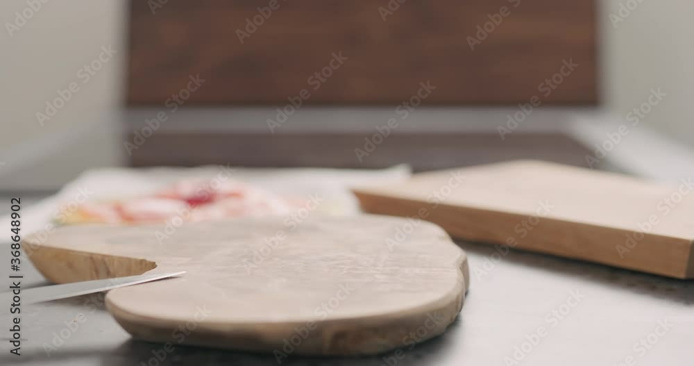 Slow motion orbit shot of man hands put ciabatta to make sandwich on wood board