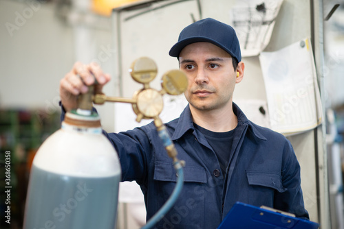 Fotografie Inspector checking a gas tank in a factory
