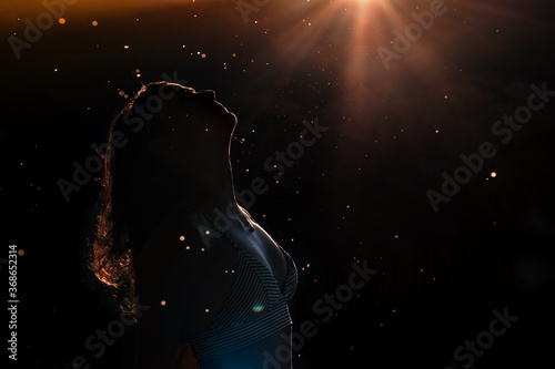 Silhouette of woman at sunset with the sun in the background