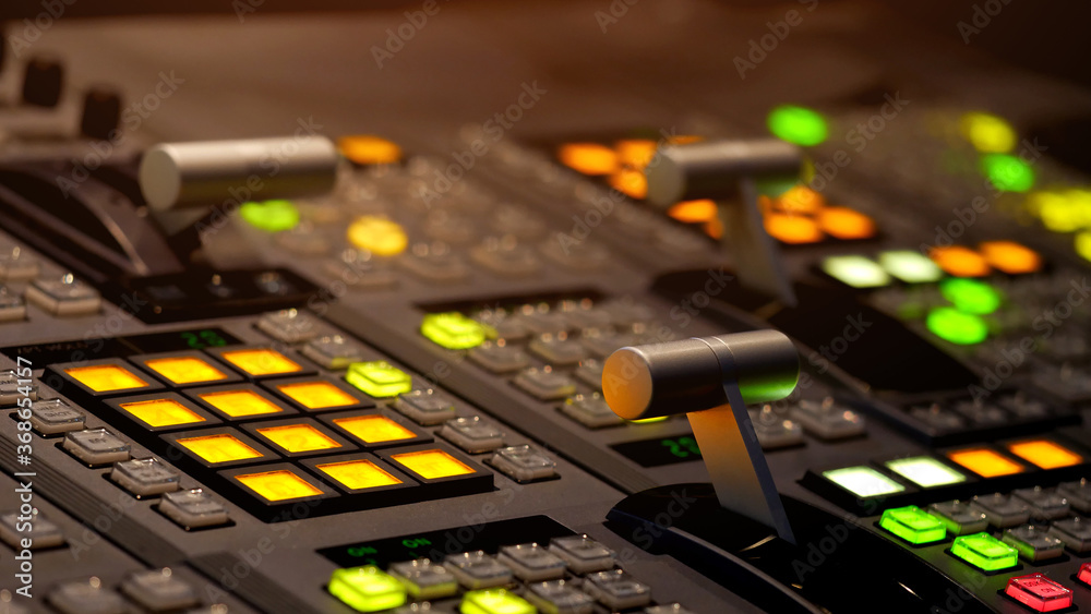 Blur image video switch of Television Broadcast, working with video and audio mixer, control broadcasts in recording studio. Broadcasting in the studio, professional mixing sender color buttons. Blur image video switch of Television Broadcast, working with video and audio mixer, control broadcasts in recording studio. Broadcasting in the studio, professional mixing sender color buttons.