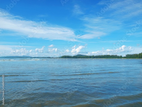 Beautiful blue sky with cumulus and cirrus white clouds. Green islands stretching out to sea. Hills on a horizon. Curls waves in a distance. Lake  forest  panorama  landscape. Bright colors of summer