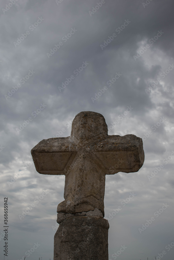 Old stone cross against sky