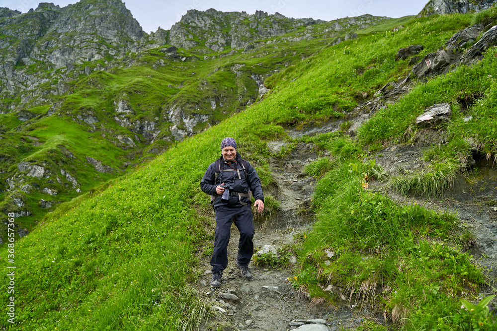 Hiker man with backpack on a mountain trail Hiker man with backpack on a mountain trail