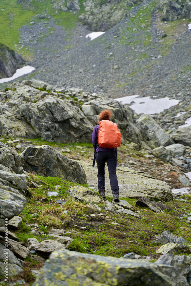 Lady hiker on a trail in the mountains