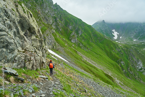 Lady hiker on a trail in the mountains