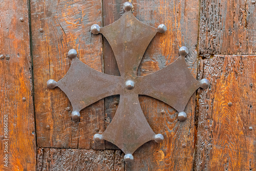 Croix en métal de l'Occitanie. Symbole de la région Occitanie-Pyrénées-Méditerranée, en France. Croix occitane sur fond de bois. photo