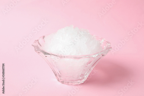 Shaving ice in glass dessert bowl on pink background, closeup