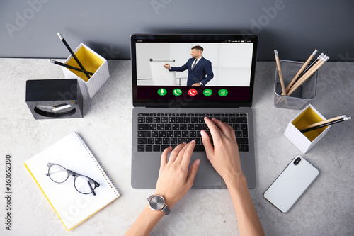 Woman having online video consultation with business trainer at table, top view