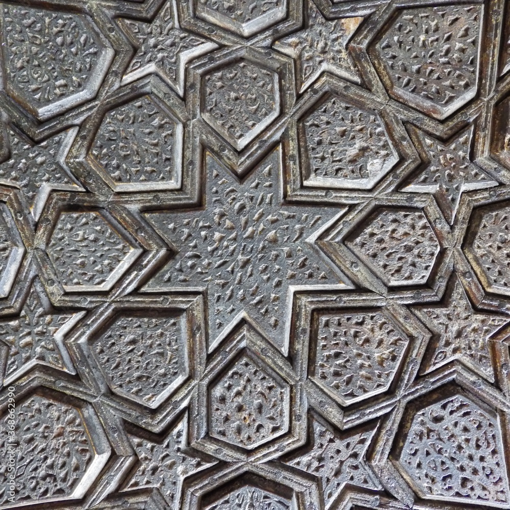 closeup geometric wood carving at the door of blue mosque at  yazd iran.