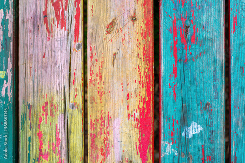 Vintage colorful wooden boards with weathered cracked paint. Retro background with old wooden planks of different colors.