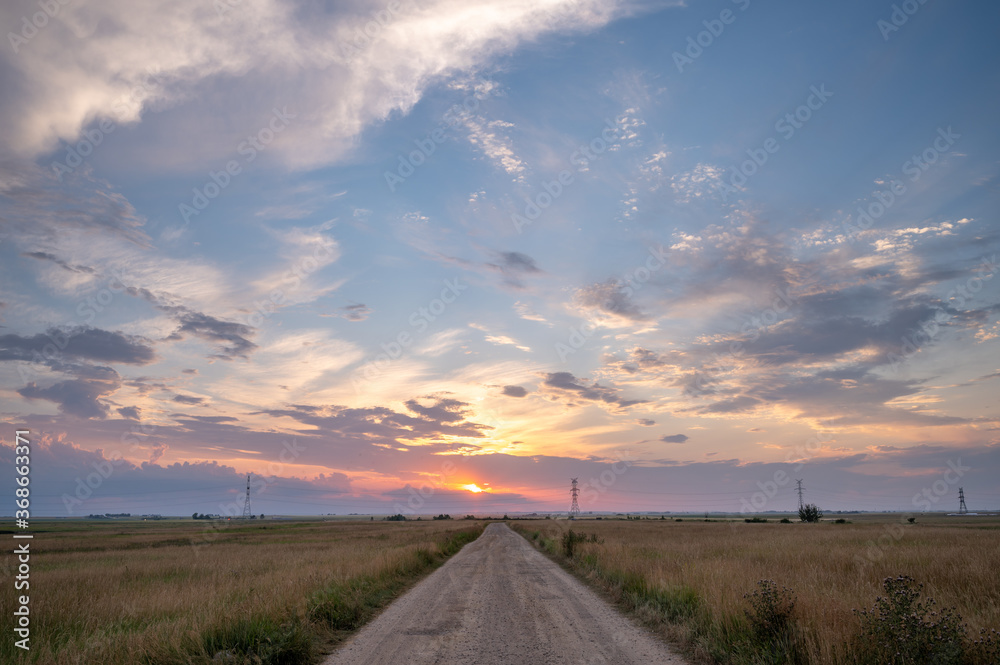 View down a rural road at sunset.