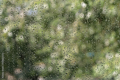 Water drops on window with green background