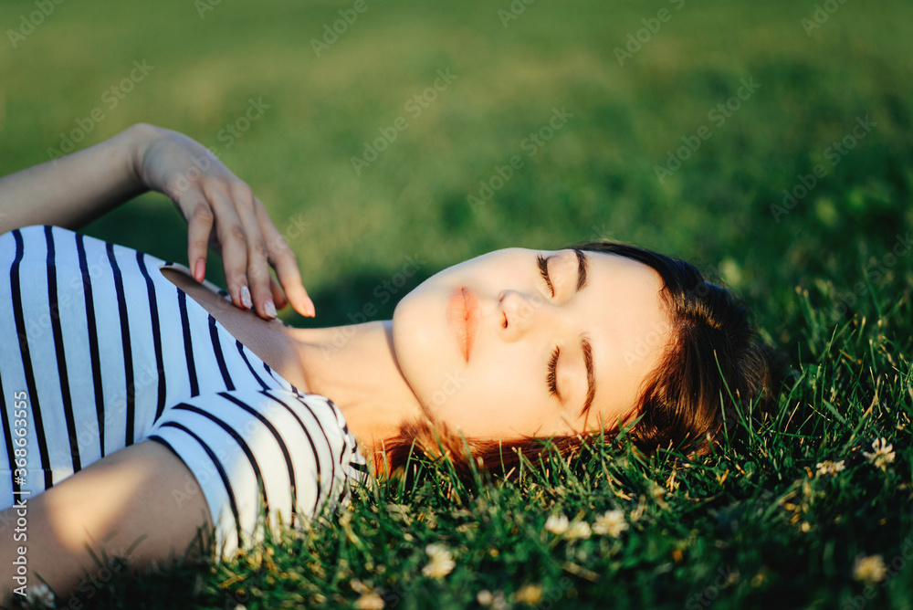 girl lies on the grass in the sun