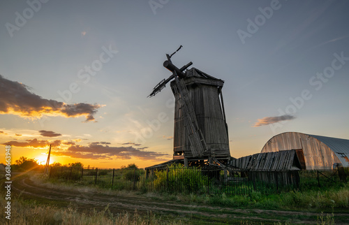 Old abandoned wooden wind mill, built in the 19th century in Samara region, Russia. Summer sunset landscape
