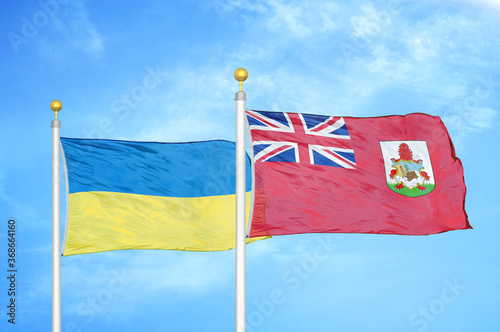 Ukraine and Bermuda two flags on flagpoles and blue sky photo