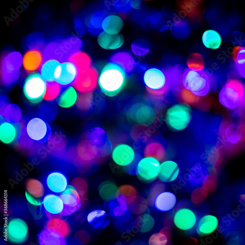 Trendy in 2021 Christmas or New Year festive blue and purple bokeh on black background. Backdrop or wallpapers.