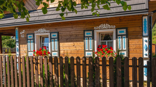 Traditional ornamented colorful open shutters of an old wooden Polish rural house in the village of Trześcianka - so called Land of Open Shutters. photo