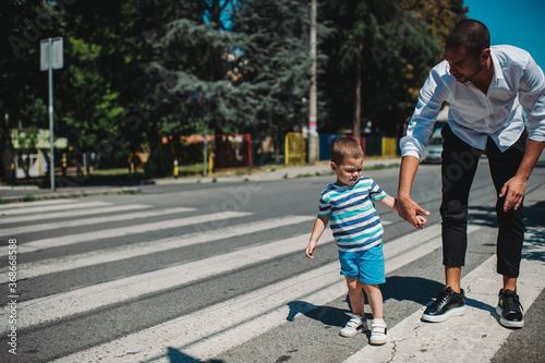 Father and son walking on street Father wearing smart casual outfit, going home after work. Unsafe walking.