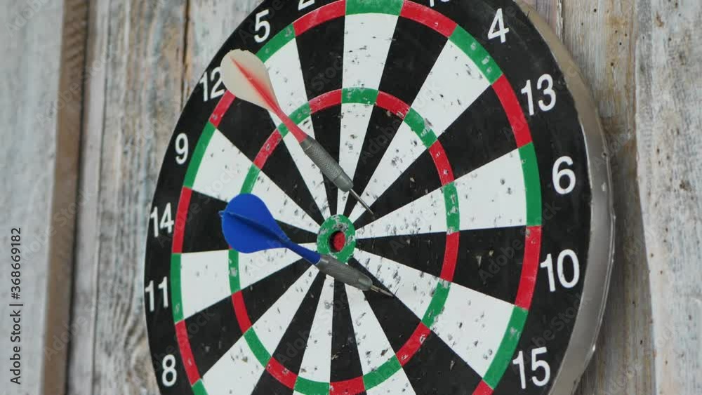 Darts fly at the target, the target is attached to the board wall Darts fly at the target, the target is attached to the board wall