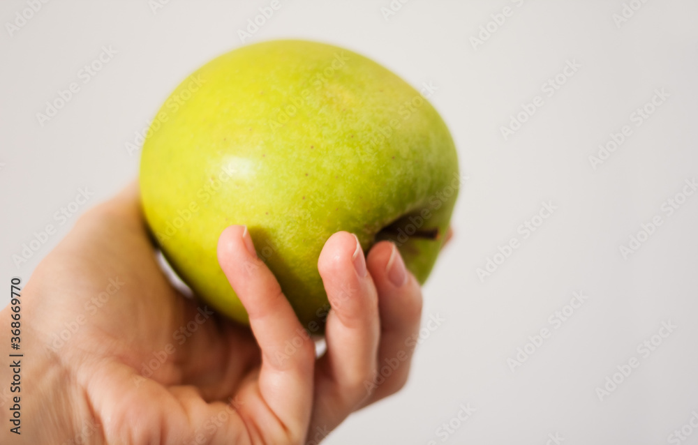 ripe fresh green apple in female hand, healthy food concept, vegetarian diet. ripe fresh green apple in female hand, healthy food concept, vegetarian diet.
