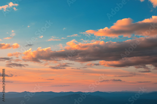 Sunset sky with clouds and red reflections from the sun. Bright colorful background © EdNurg