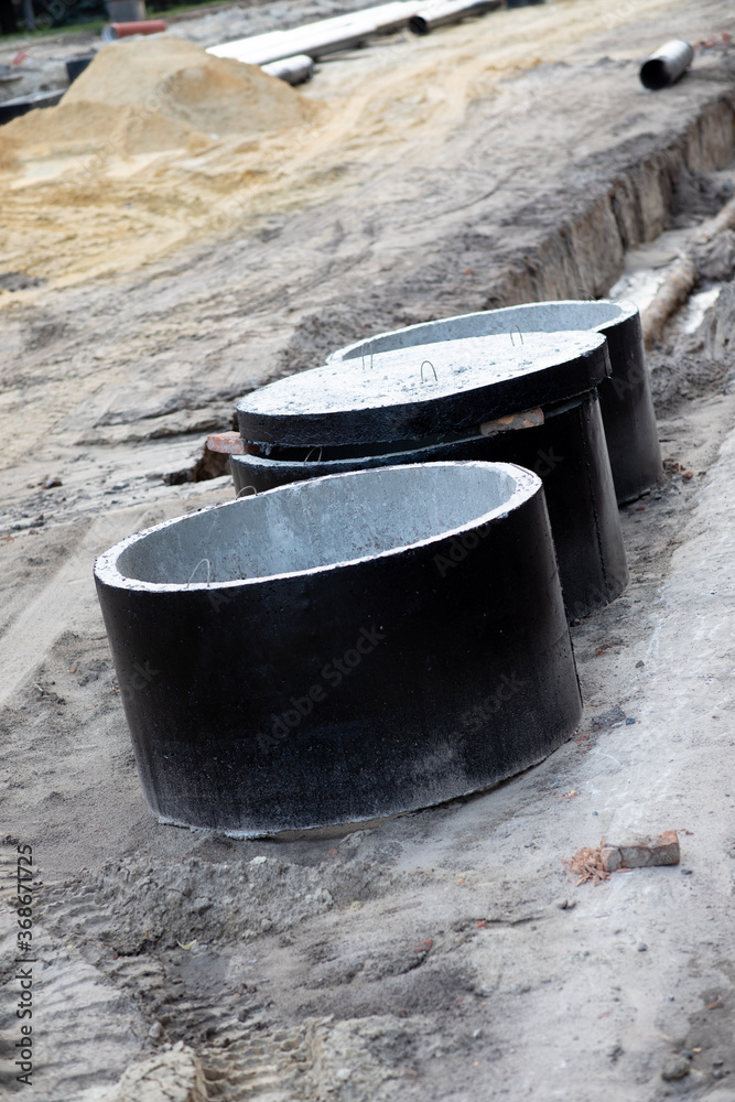 Several large black concrete wells for plumbing at a construction area Several large black concrete wells for plumbing at a construction area