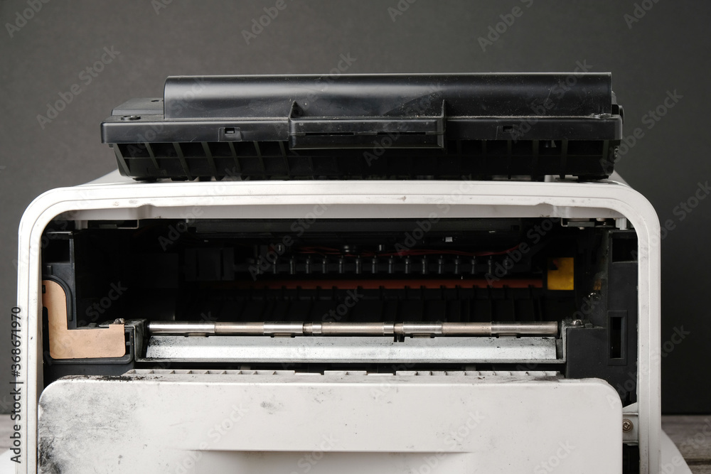 Old laser printer with cartridge on black background, office equipment repair concept Old laser printer with cartridge on black background, office equipment repair concept