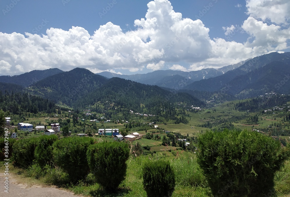 aerial view of a valley with blue cloudy sky in the background