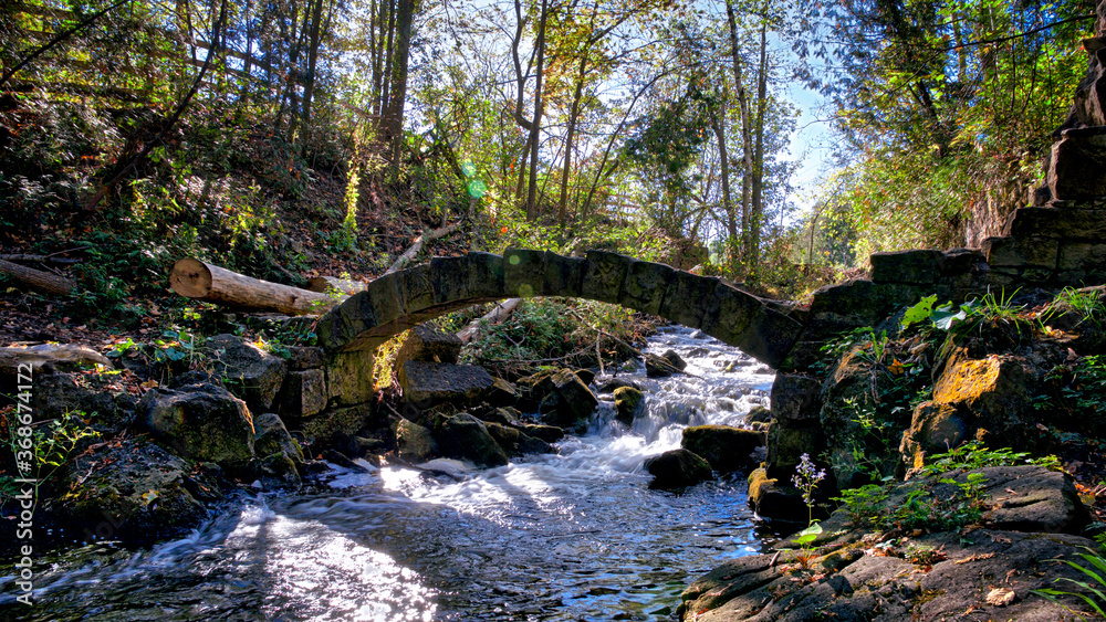 Stone bridge over the river rapid in autumn Stone bridge over the river rapid in autumn