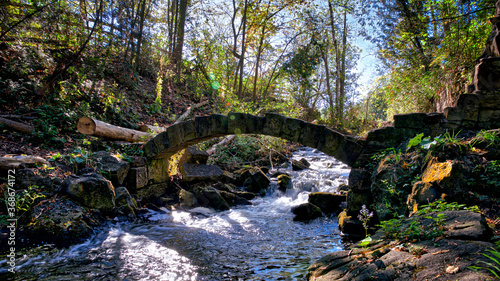 Stone bridge over the river rapid in autumn