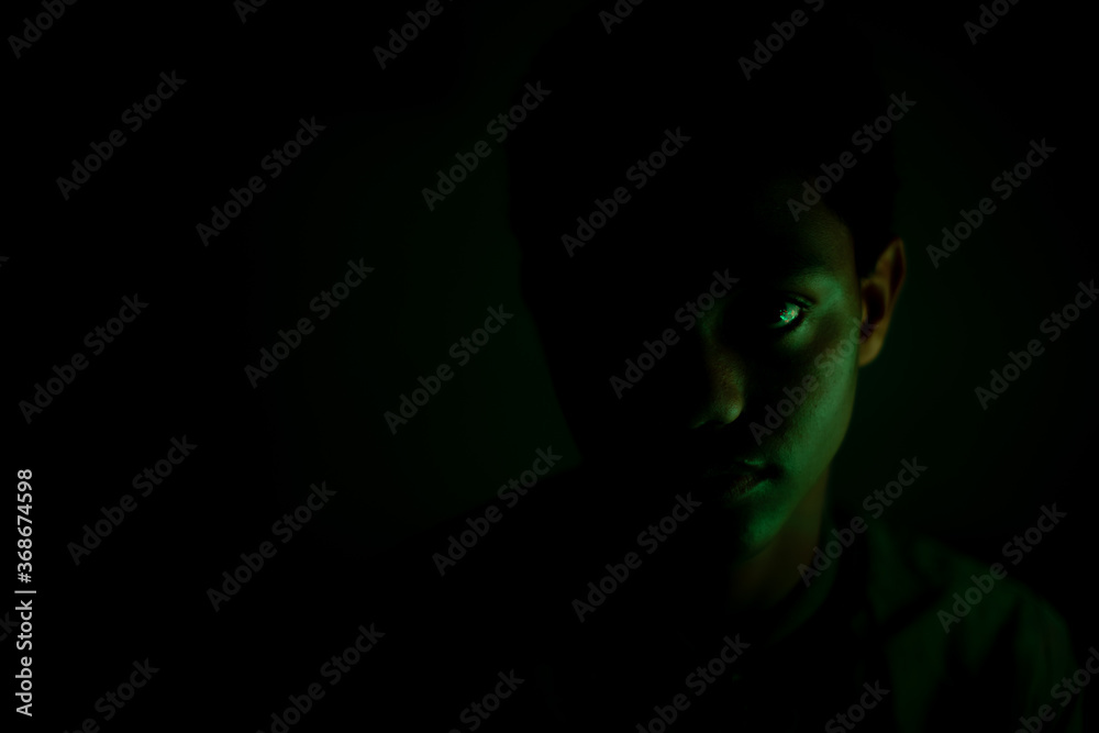 Portrait of teenager staring in dark room