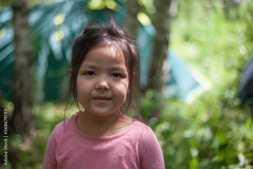 Girl 4 years old in the forest. Little girl of Asian appearance Girl 4 years old in the forest. Little girl of Asian appearance