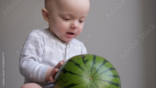Cute little baby girl playing with watermelon.